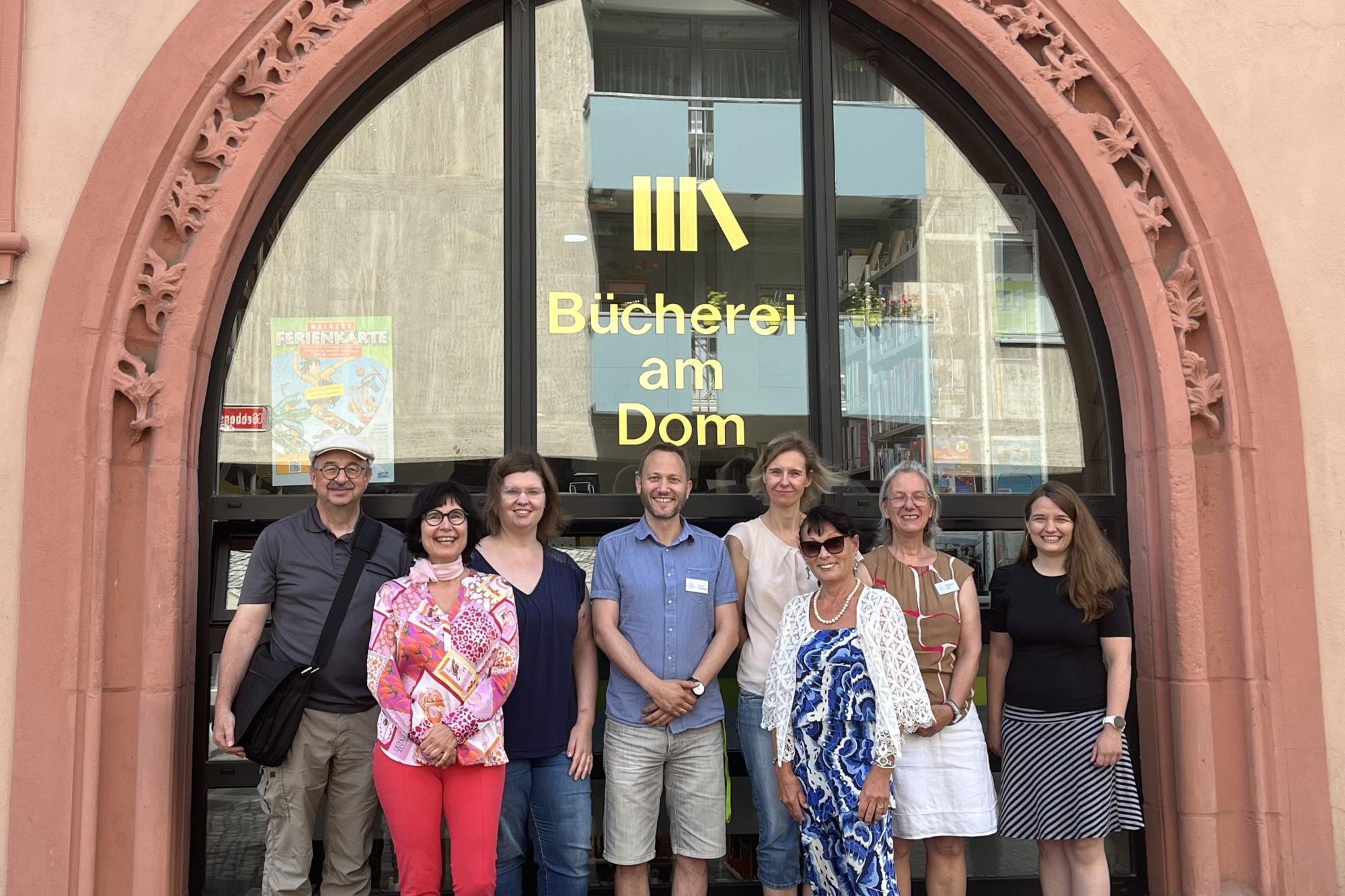 Teamfoto vor der Bücherei am Dom Mainz: Regensburg trifft Mainz – Austausch und Zusammenarbeit.