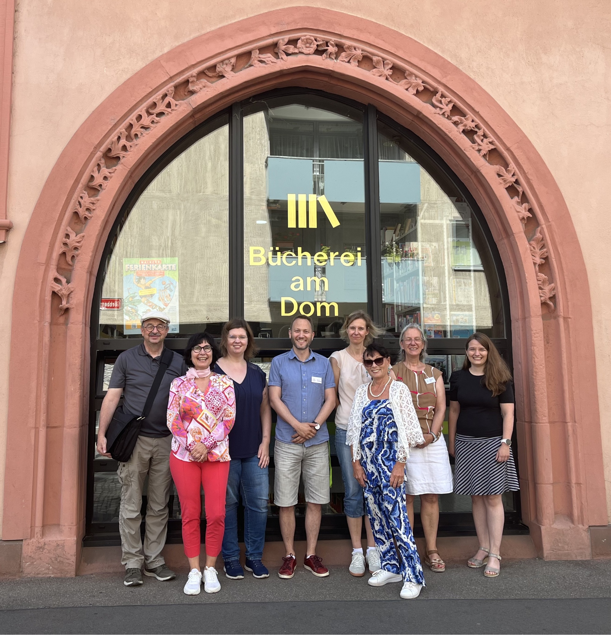 Teamfoto vor der Bücherei am Dom Mainz: Regensburg trifft Mainz – Austausch und Zusammenarbeit.