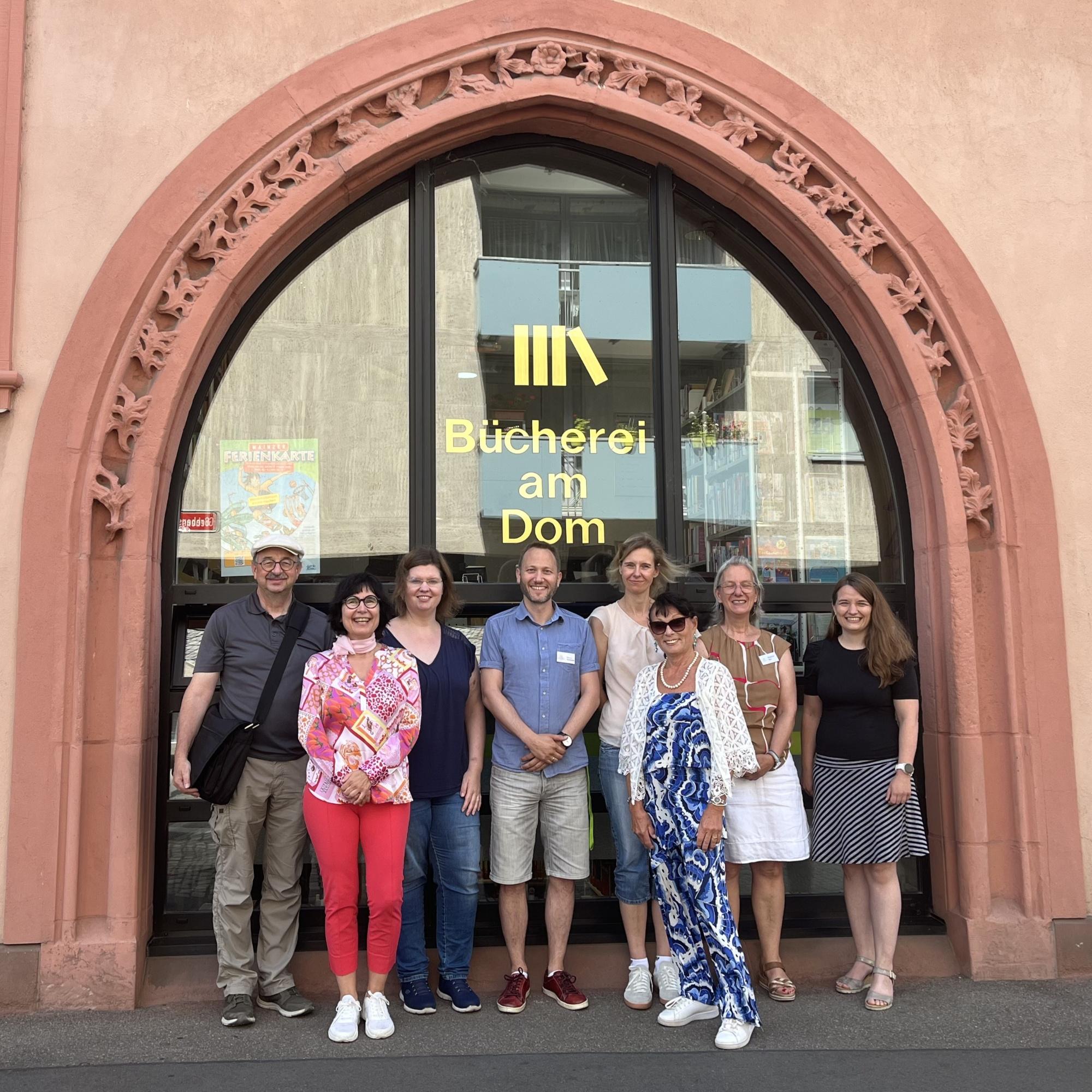 Teamfoto vor der Bücherei am Dom Mainz: Regensburg trifft Mainz – Austausch und Zusammenarbeit.